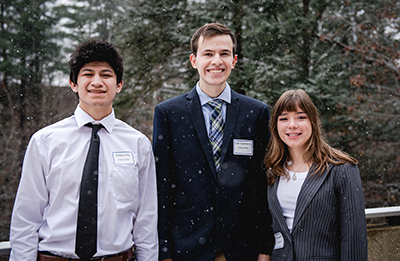 three students standing outside