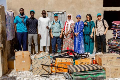 people standing outside with goods on the ground