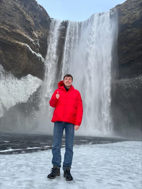 Brett standing in front of a snowy waterfall