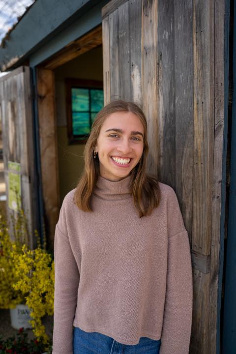 person standing outside by a wooden building
