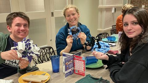 students at a table doing a craft