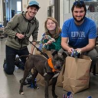 students sitting with a dog on a leash