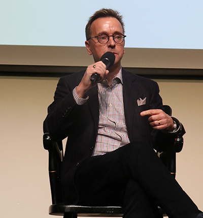 person sitting in a chair talking into a microphone