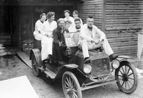 Vintage photo of car overloaded with passengers.