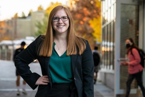 Student in professional attire outside during fall