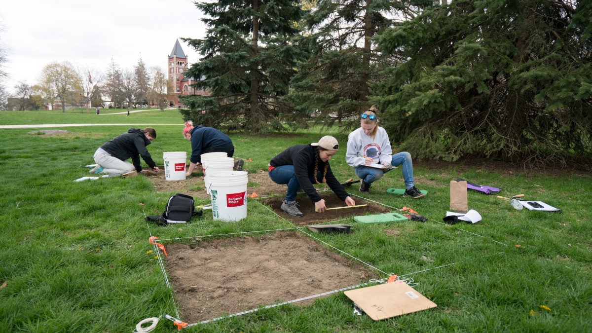 UNH archaeology students digging