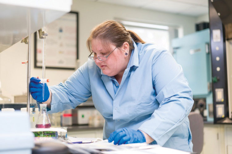 UNH student Becky Baker '16 adjusting instruments in a lab