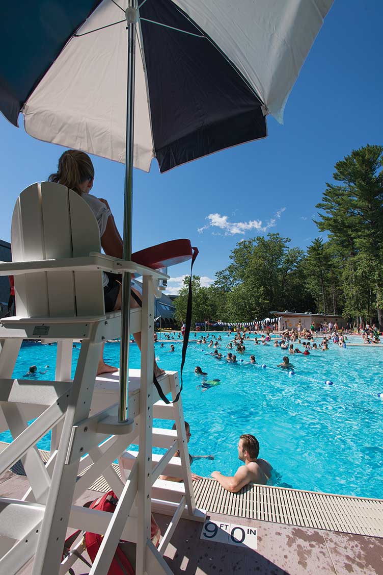 a lifeguard watching people swimming at UNH's new outdoor pool