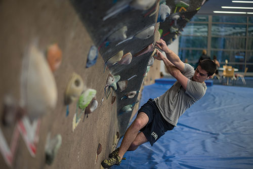a UNH student using the climbing wall in the new expanded Hamel Rec Center