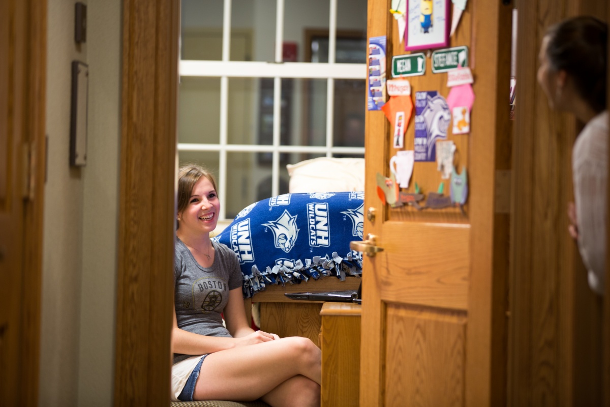 Girls chatting in dorm room with door open