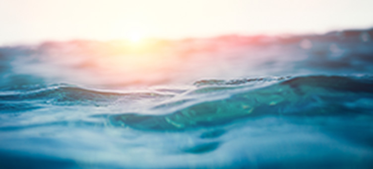 close up of ocean waves with the sun setting