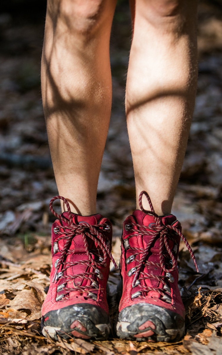 UNH student standing in hiking boots in College Woods, Durham, NH