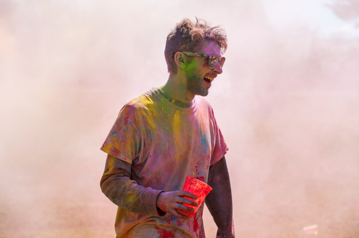 UNH student covered in colored chalk during Holi celebration