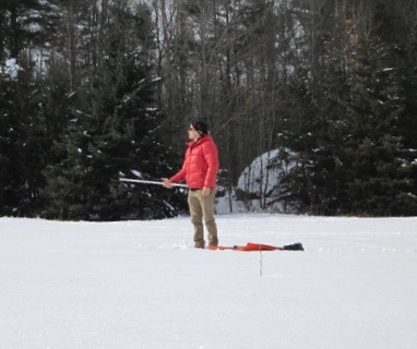 Tristan Amaral takes measurements of snow albedo.