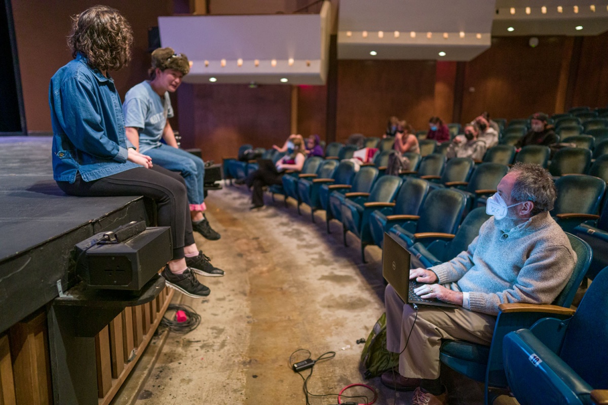 two students on Johnson stage, discussing scene/play with David Richman in front row