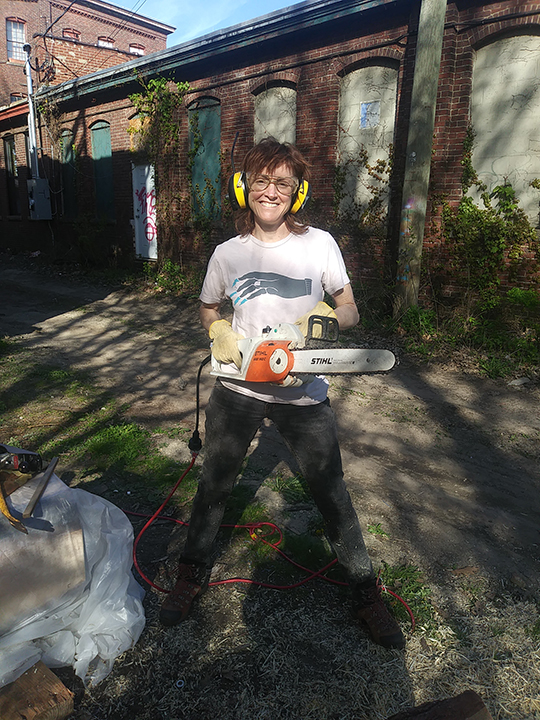 Leah Woods holding chainsaw