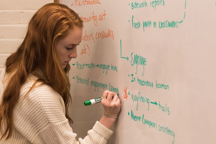 student writing on whiteboard