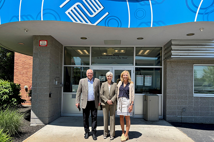 A man and two women pose outside of the Boys and Girls Club