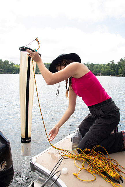 Woman working in the water over the side of a boat