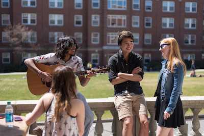 UNH students talking and playing guitar outside