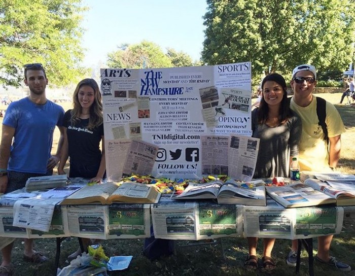 UNH student Allison Bellucci and other members of The New Hampshire at their booth at University Day