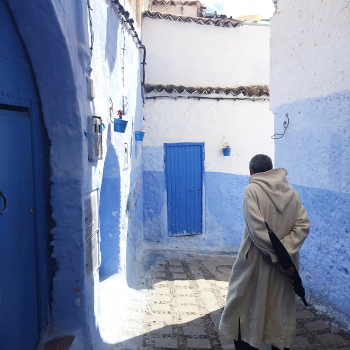 a man walking through Chefchaouen, Morocco