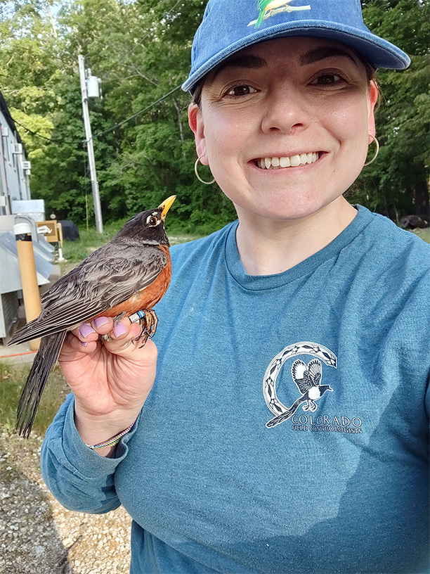 Urban ecology specialist Karina Sanchez holds an American robin on her hand.
