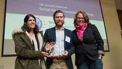 The third-place winner of the community track, Justin Troiano (center), a master's student in political science, with team member Emilia Giordano (left).