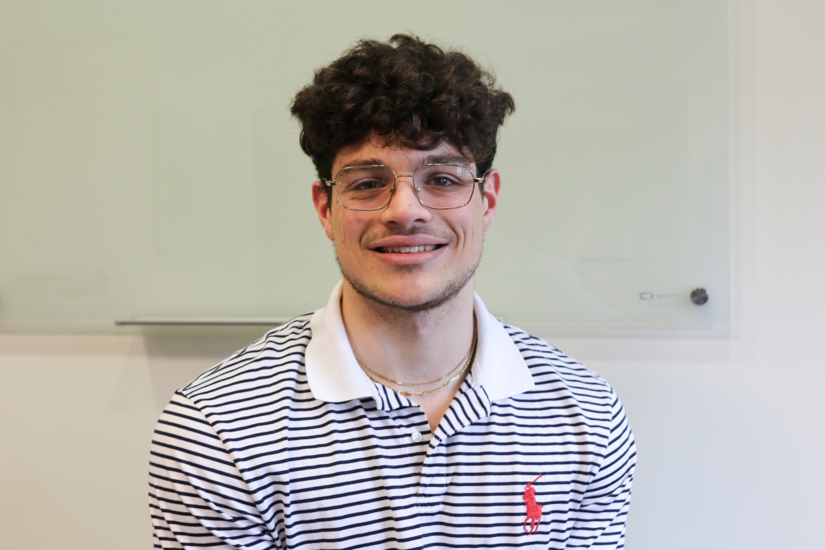 Portrait of male UNH student with dark hair and glasses