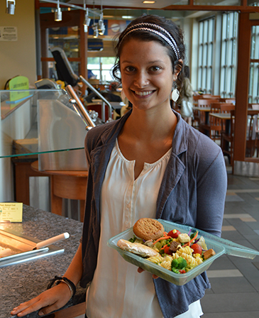 student holding a UNH to-go box