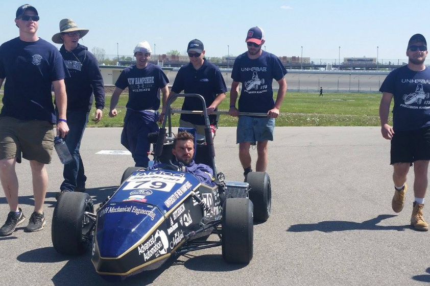 UNH students with a racecar