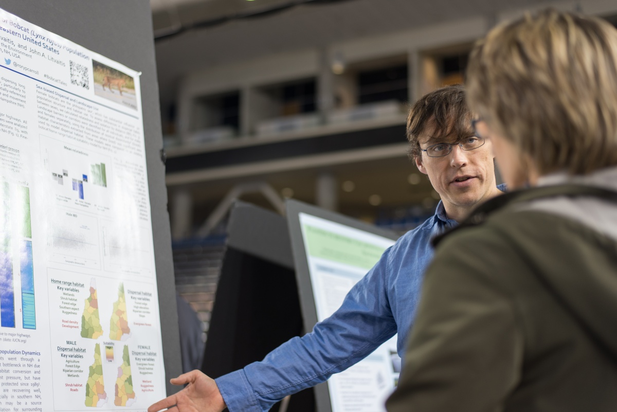 Two people look at a research poster