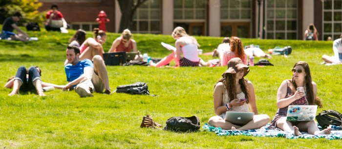 UNH students sitting on Thompson Hall lawn