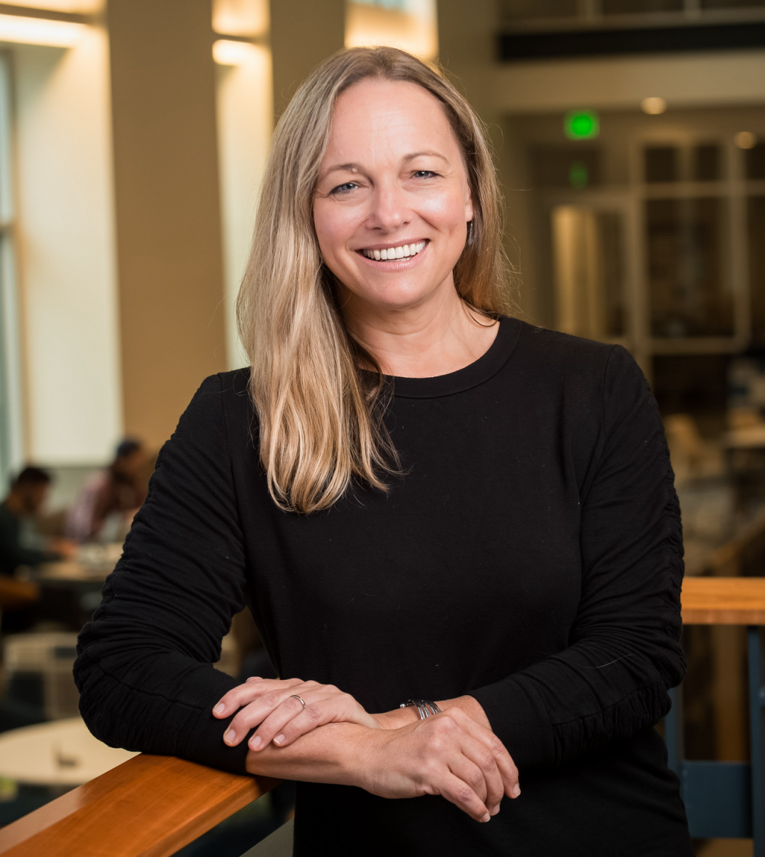 Female UNH researcher with blonde hair wearing black top looks at the camera