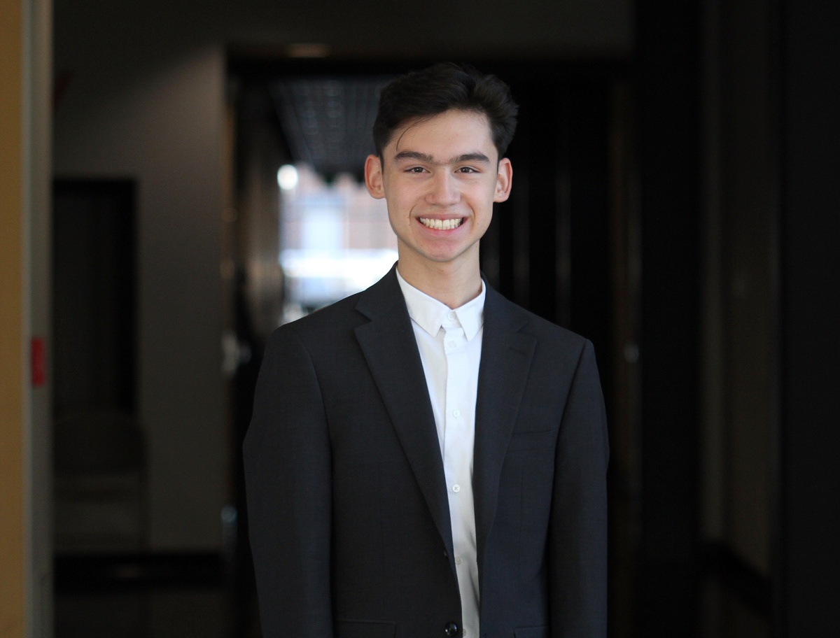 Portrait of male UNH student wearing white shirt and suit jacket