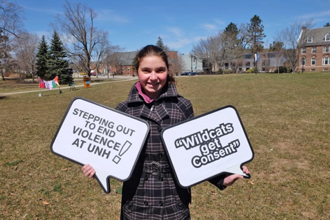 UNH student with step out sign