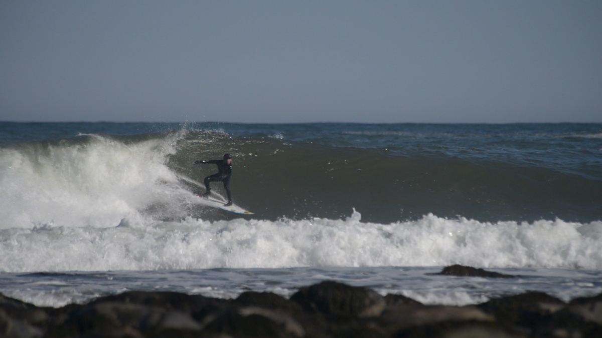 A UNH surfer rides a wave