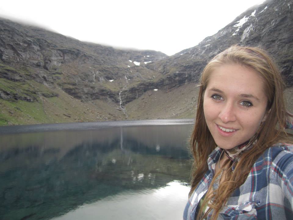 Samantha Werner sits at the edge of a lake in Sweden