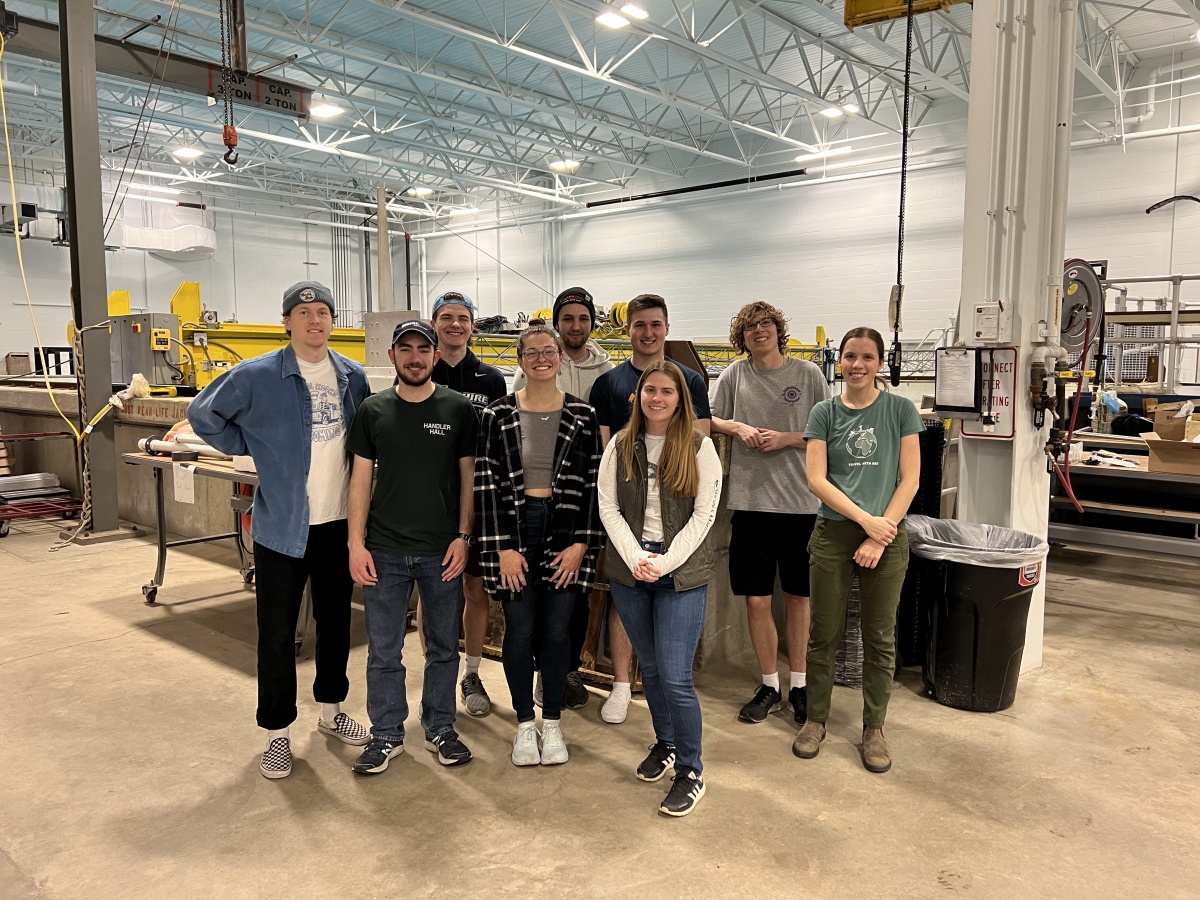 Group of students faces camera, standing in ocean engineering lab