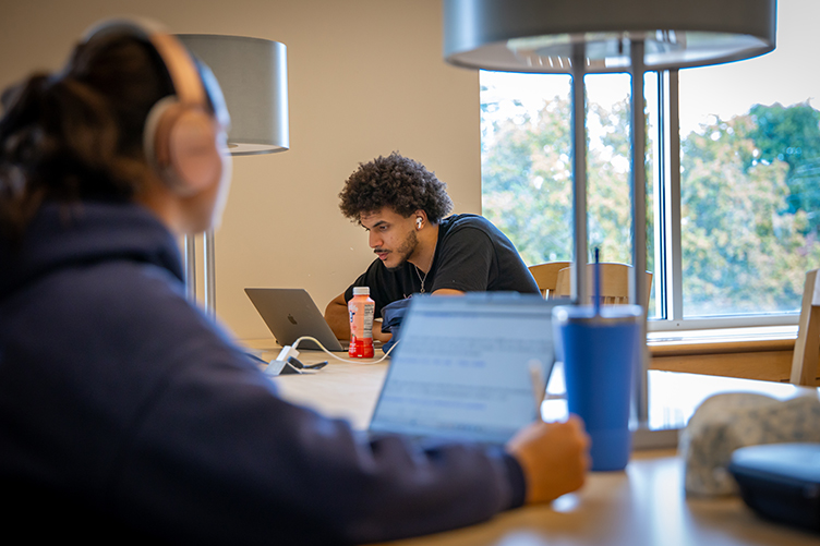 A student studies at a table in the library