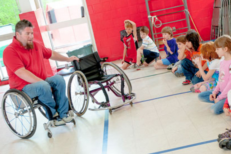 chandler bullard with students in gym