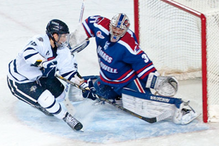 men's ice hockey player at goal against competing team