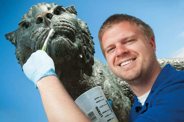 jameson coop cleaning the wildcat sculpture