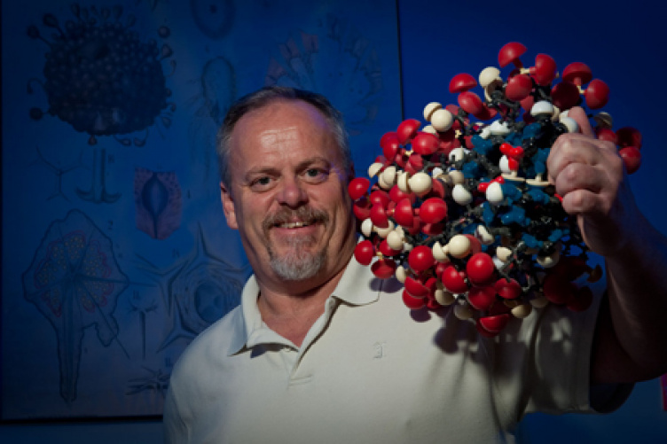 W. Kelley Thomas, Hubbard Professor of genomics and director of the UNH Hubbard Center for Genome Studies Professor Kelley Thomas holding a large molecule model