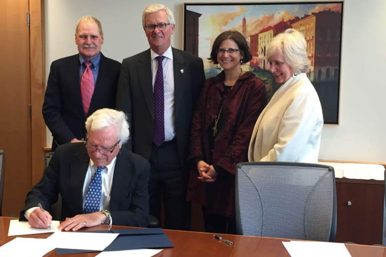 Jeffrey Sohl, director of UNH's Center for Venture Research;UNH President Mark Huddleston; UNH Provost Lisa MacFarlane; and Deborah Merrill-Sands, dean of the UNH's Paul College of Business and Economics; look on as Mel Rines '47 signs papers establishing a student angel investment fund in his name.