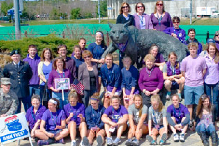 cooperative extention volunteers in front of cat sculpture