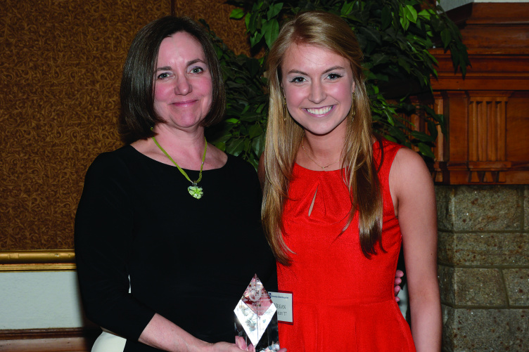Christine Carberry '82 and Megan Cooley '17 pose for a photo with an award.