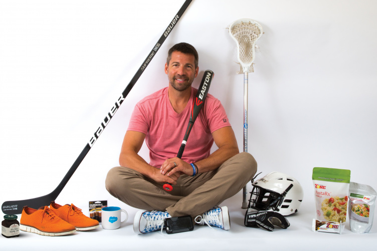Erik Dodier '92 poses with products created by PixelMEDIA's clients.
