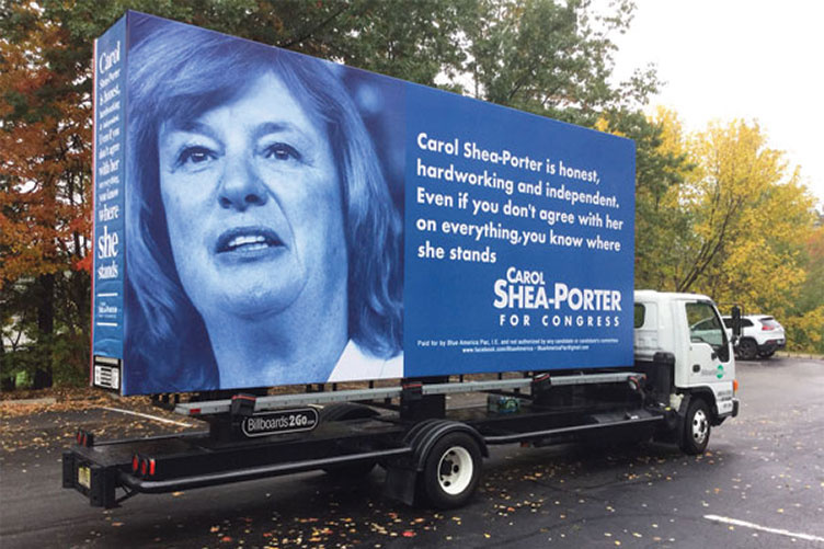 a large Carol Shea-Porter campaign sign on a truck