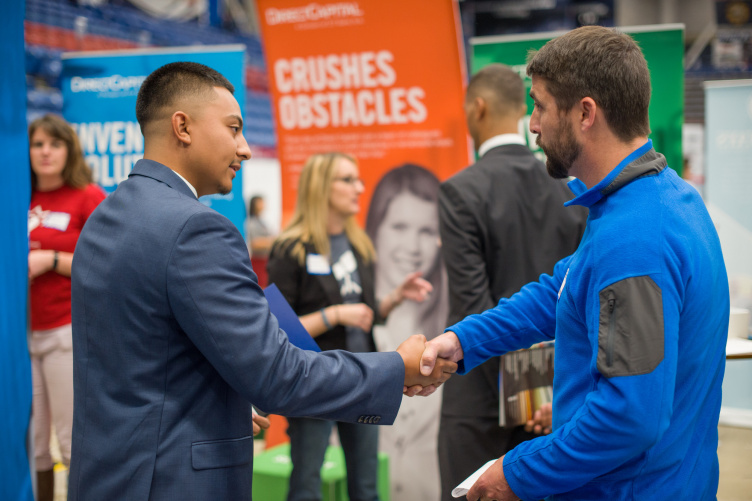 student and employer shake hands at the fall 2017 Career and Internship Fair